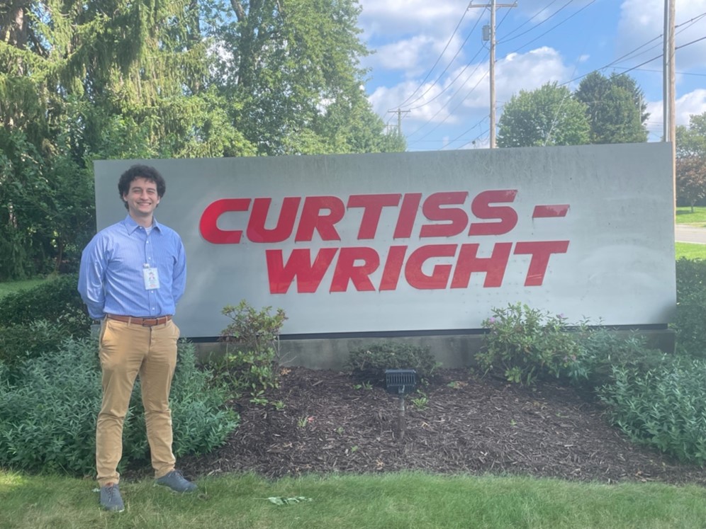 Chris Kefalos in front of curtiss wright sign