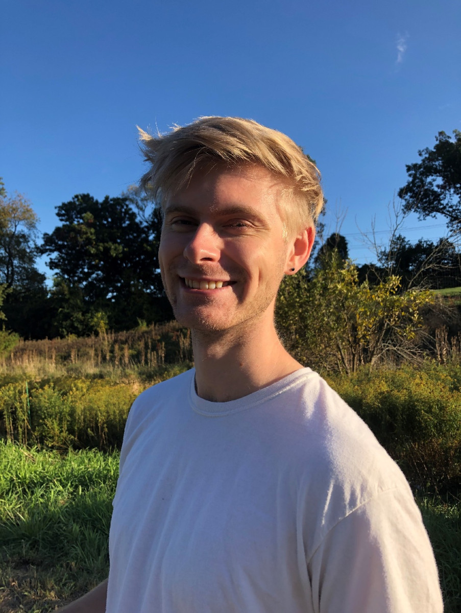 Ian Eder smiling outdoors in a field