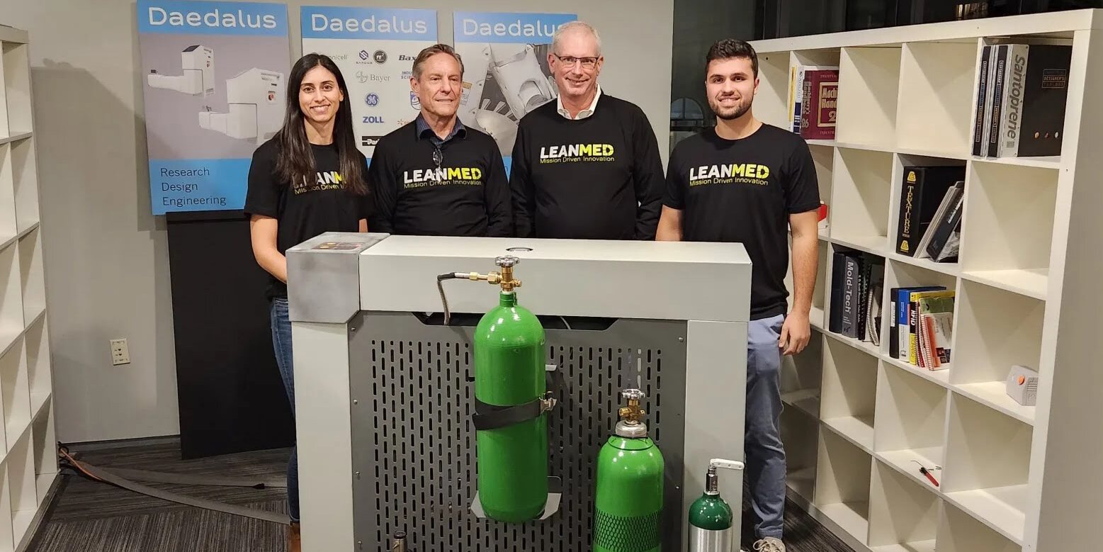 Four individuals stand behind an O2 cube