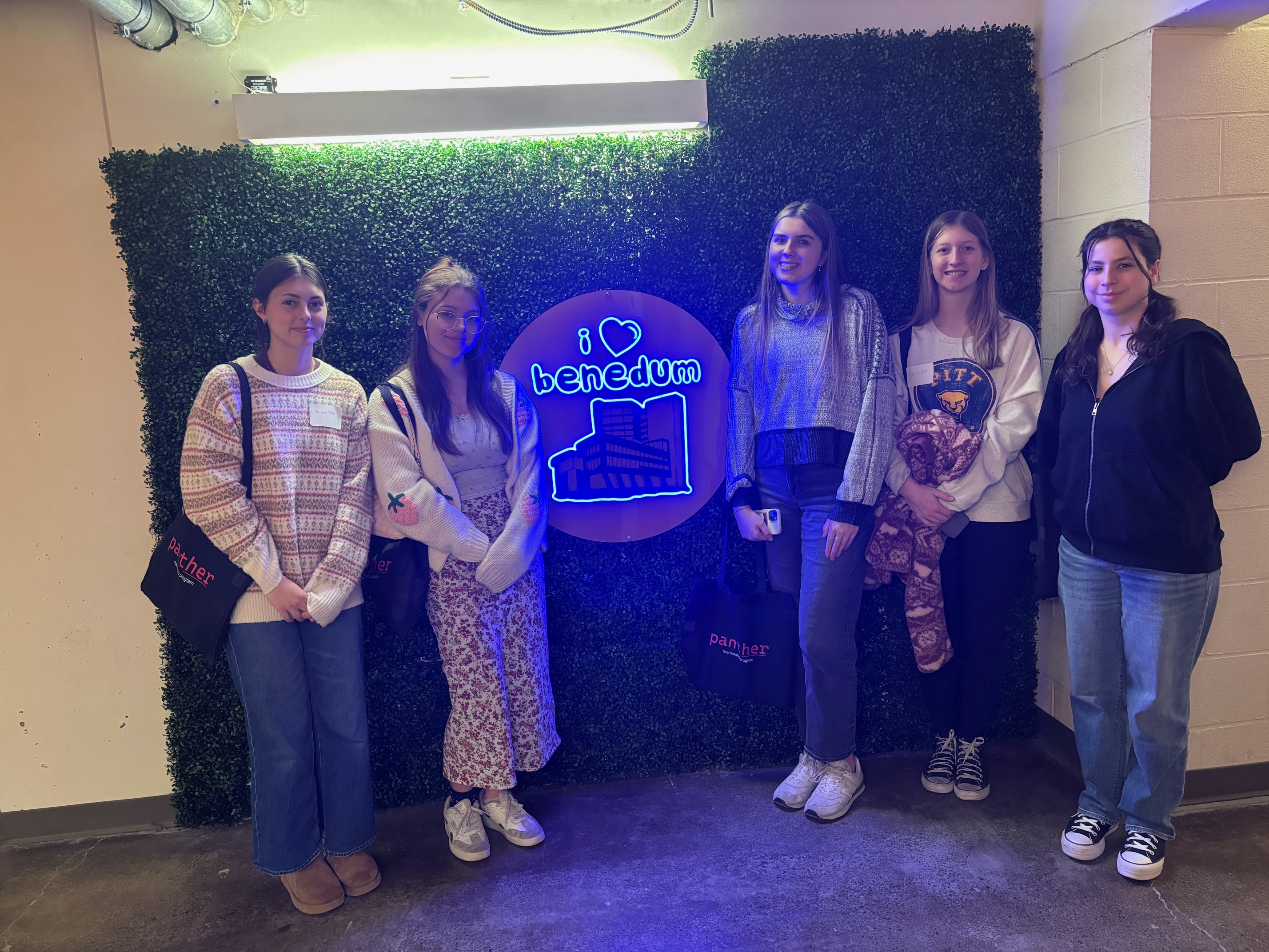 Five women students standing by the I Love Benedum neon sign