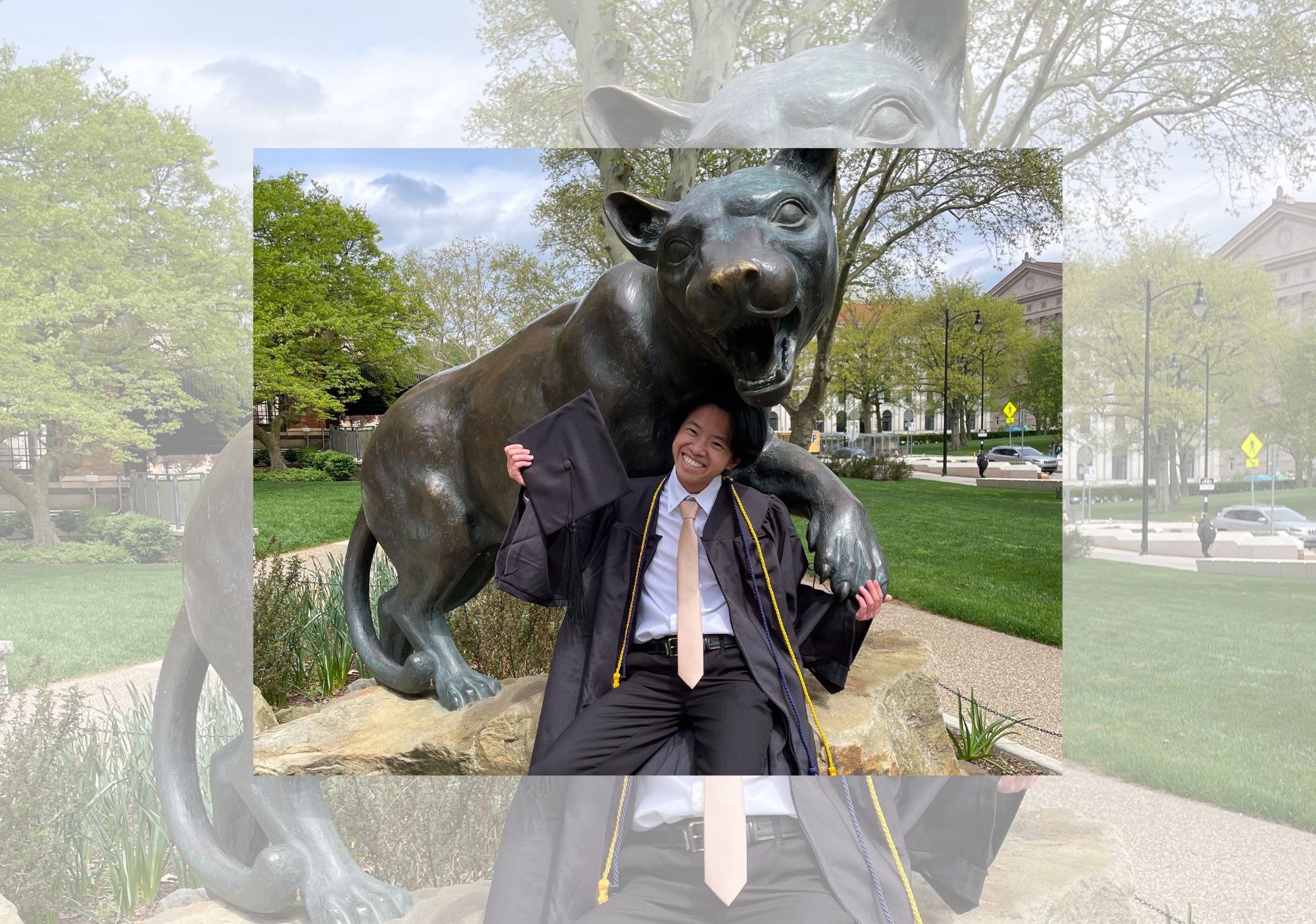 Percy Curtis in front of a panther statue during graduation