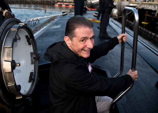 Tom Congedo smiles while climbing out of a nuclear submarine hatch