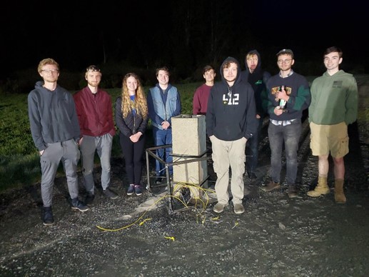 Group photo of students at night with launch equipment